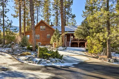 a log home in the woods with a driveway at Pine Mountain Club Log Home with Deck and Grill! in Pine Mountain Club