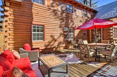 a wooden cabin with a patio with a table and chairs at Pine Mountain Club Log Home with Deck and Grill! in Pine Mountain Club