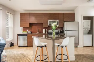 a kitchen with a island with two white stools at Tulum Vibes 1 Bedroom Apartment near Boats in Marina Del Rey in Los Angeles