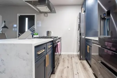 a kitchen with blue cabinets and a refrigerator at Fam Friendly 2BD 8min from airport, 4min from SoFi in Los Angeles