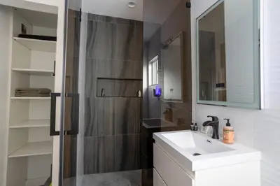 a bathroom with a shower and a sink and a mirror at Fam Friendly 2BD 8min from airport, 4min from SoFi in Los Angeles
