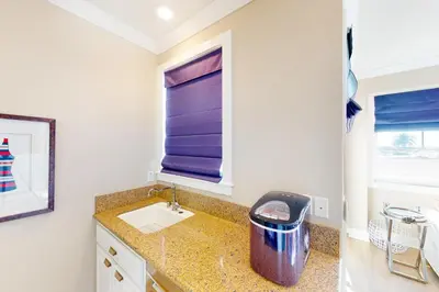 a small bathroom with a sink and a window at Gull Cottage in Seal Beach