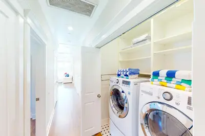 a laundry room with a washer and dryer at Gull Cottage in Seal Beach