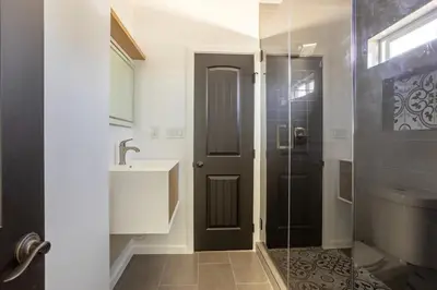 a bathroom with a shower and a sink and a glass door at Coziest 1BD Bungalow 8min from airport, 4 min SoFi in Los Angeles