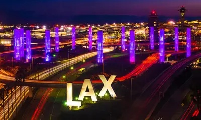 a night view of a freeway with a lit up lax at Coziest 1BD Bungalow 8min from airport, 4 min SoFi in Los Angeles