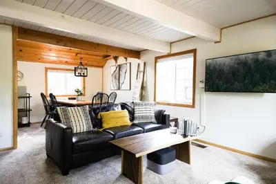 a living room with a leather couch and a table at Aery Pines in Wrightwood
