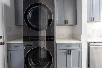 two washing machines in a kitchen with white cabinets at Bungalow w Free Parking 4 min from SoFi, 8min from airport in Los Angeles