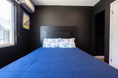 a bedroom with a blue bed with a pillow at Newly Renovated Bungalow w Free Parking 4min from SoFi, 8min from Airport in Los Angeles