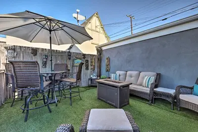 a patio with a table and chairs and an umbrella at Walk to Ventura Beach Comfy Home with Ocean Views in Ventura