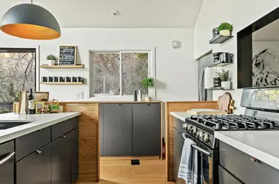 a kitchen with gray cabinets and a stove at Modern Treetop Cabin by Lake Arrowhead Village in Lake Arrowhead