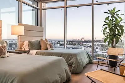 two beds in a room with large windows at @ Marbella Lane - Aesthetic 2BR w/Ocean views in Long Beach