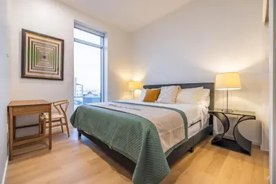 a bedroom with a bed and a desk and a window at @ Marbella Lane - Aesthetic 2BR w/Ocean views in Long Beach