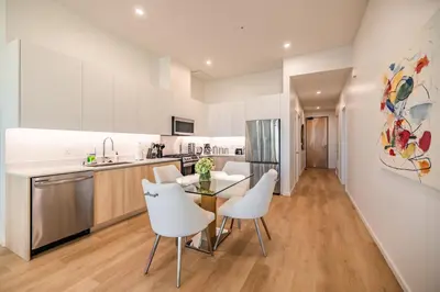 a kitchen and dining room with white chairs and a table at @ Marbella Lane - Luxury Beachside 2BR in Long Beach