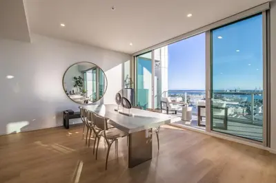 a dining room with a table and chairs and a large window at @ Marbella Lane - Luxurious 3BR Penthouse in Long Beach