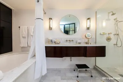 a bathroom with a tub and a sink and a mirror at The Eden in Los Angeles
