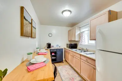 a kitchen with wooden cabinets and a white refrigerator at Quiet Carpinteria Cottage By Town and Beaches in Carpinteria