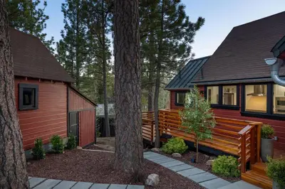 a home with a large wooden bench next to a tree at Sled-Ski Snow Summit Lakeside Village - Spa - BBQ - Firepit - Loft - Games in Big Bear Lake