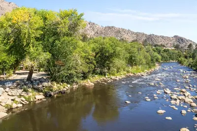 a river with rocks and trees and mountains in the background at Adorable little cabin #21 in Kernville