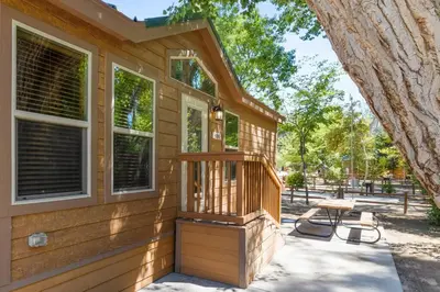 a wooden house with a porch and a picnic table at Adorable little cabin #26 in Kernville