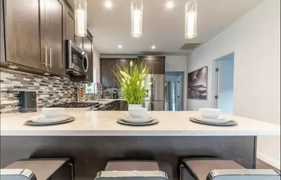 a kitchen with a island with chairs and a counter top at Gorgeous DTLA w/ View + Hot Tub! in Los Angeles