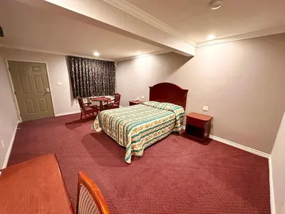 a hotel room with a bed and a table at Tropic West Motel in Bell