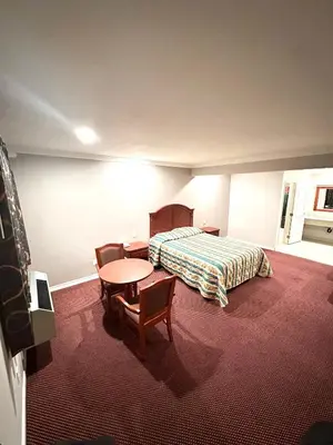 a hotel room with a bed and a table and chairs at Tropic West Motel in Bell