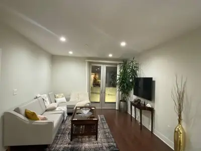 a living room with a white couch and a tv at Glendale Americana 2 Bedroom 2 Bathroom Condo in Glendale