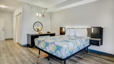 a hotel room with a bed and a mirror at Motel 6 Highland CA San Bernardino East in Highland
