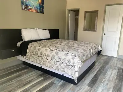 a bedroom with a bed with a black and white comforter at City Center Motel - Oxnard in Oxnard