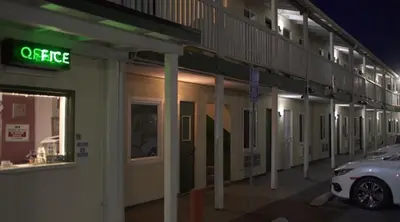 a car parked outside of a building at night at City Center Motel - Oxnard in Oxnard