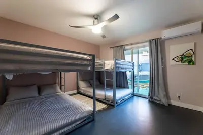 two bunk beds in a room with a ceiling fan at Modern San Pedro Home, Sleeps 12, Hot Tub, Fire Place, Private Parking in San Pedro