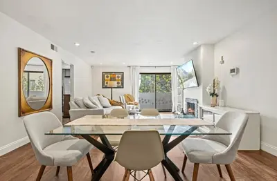 a dining room with a glass table and chairs at Elegant Hollywood Retreat - Spacious 2BR 2BA Condo with Resort-Style Amenities in Los Angeles
