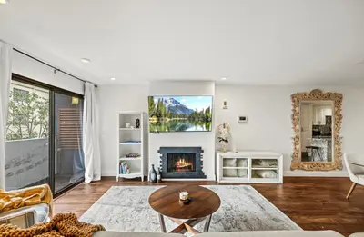 a living room with a fireplace and a table at Elegant Hollywood Retreat - Spacious 2BR 2BA Condo with Resort-Style Amenities in Los Angeles