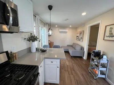 a kitchen and living room with a stove top oven at La Casita de Whittier, Private Unit w/patio area, Disney, Biola, Knotts in Whittier