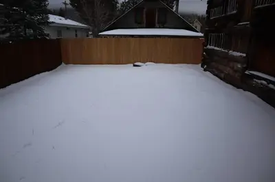 a yard covered in snow next to a fence at The Blue Lake Cabin! 1 min Walk to SnowPlay! in Big Bear City