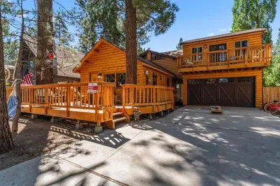 a log home with a deck and a garage at The RobinHood Retreat! A 1 min Walk to SnowPlay! in Big Bear City