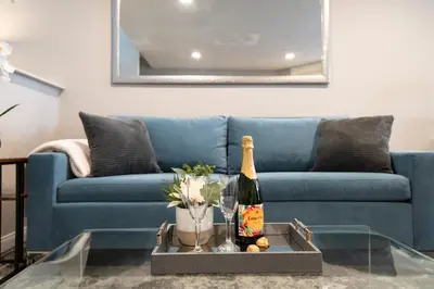 a living room with a blue couch and a bottle of champagne at Skyline Terrace Executive Jr One Bedroom with Balcony and Pool in Los Angeles