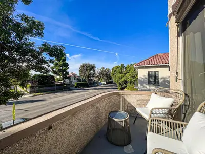 a balcony with two chairs and a street at Stylish Residence in Los Angeles - OL-WH in Los Angeles