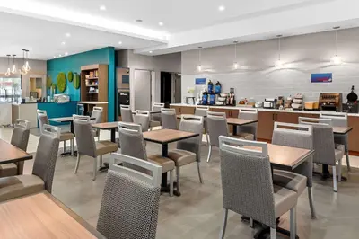 a restaurant with tables and chairs and a kitchen at Best Western San Bernardino Hotel in San Bernardino