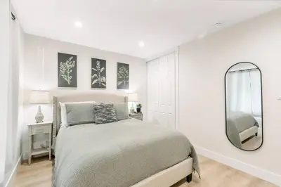 a white bedroom with a bed and a mirror at Gameroom Sofi Stadium Forum Backyard BBQ in Hawthorne