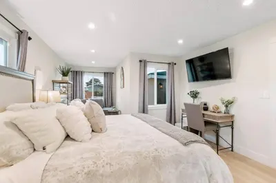 a bedroom with a large white bed and a desk at Gameroom Sofi Stadium Forum Backyard BBQ in Hawthorne