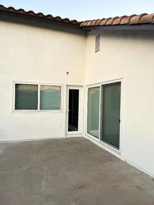 a white house with large sliding glass doors at Cozy Family Home - 20 Mins from Disneyland in Placentia
