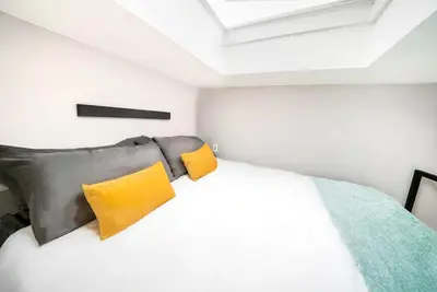 a bedroom with a bed with yellow pillows at Bright European Loft In Venice Beach in Los Angeles