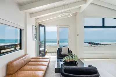a living room with a view of the beach at Luxury Modern Designer Beach House on Sand w/ Pool in Ventura