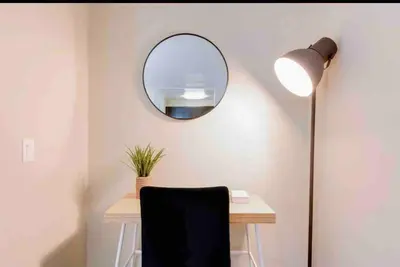 a desk with a lamp and a mirror on a wall at The Nest a Spacious 1 Bedroom Apartment with a Pool View in Los Angeles