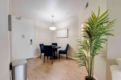 a room with a table and chairs and a plant at The Nest a Spacious 1 Bedroom Apartment with a Pool View in Los Angeles