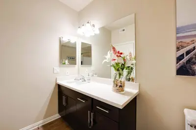 a bathroom with a sink and a vase of flowers at The Nest a Spacious 1 Bedroom Apartment with a Pool View in Los Angeles