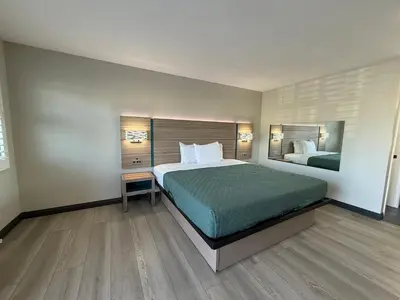 a bedroom with a large bed and a mirror at Rosemead Motel in Rosemead