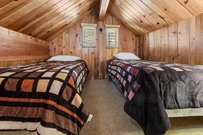 a bedroom with two beds in a wooden cabin at Paradise Cabin in Big Bear City
