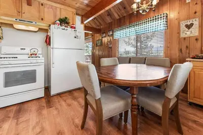 a kitchen with a table and a white refrigerator at Paradise Cabin in Big Bear City